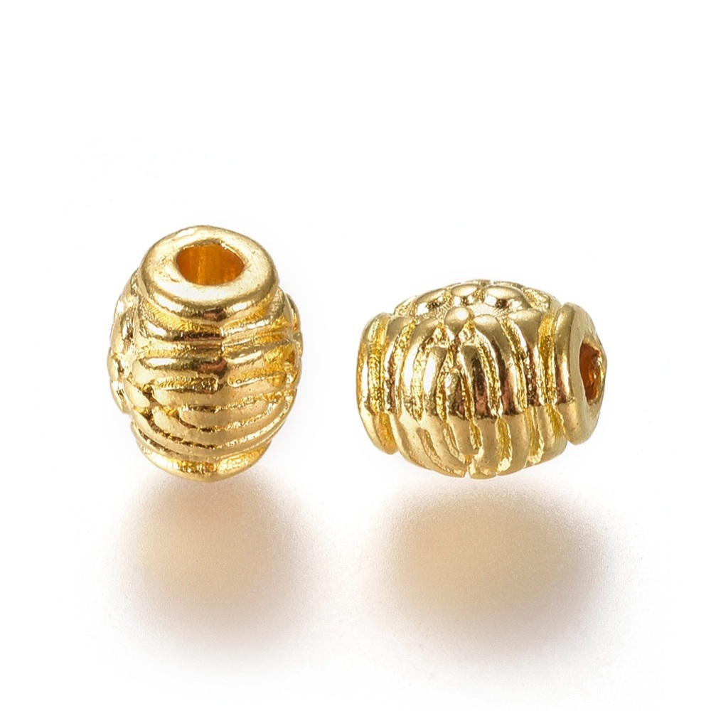 Perle laiton doré, forme ovale style tibétain, diam 6mm trou 1.5mm